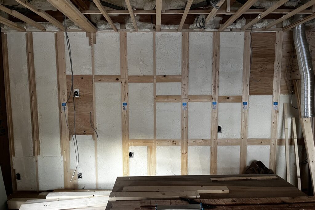 壁内部の構造材と断熱材、配線計画が確認できる施工中の室内の様子
