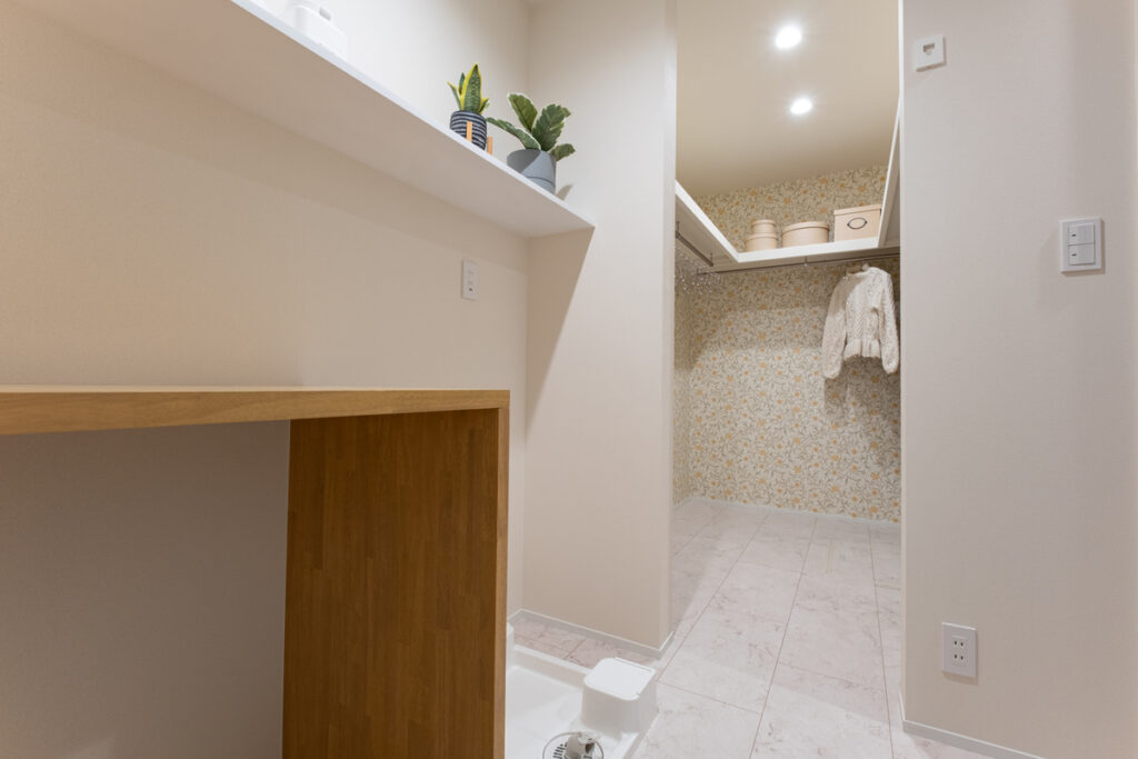 花柄のアクセントクロスが印象的なウォークインクローゼットと、家事効率を高めるために隣接して設けられたユーティリティスペース。